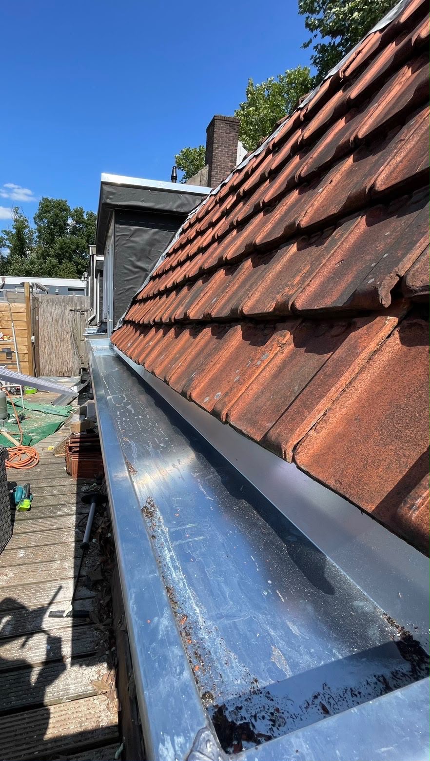 Dakrenovatie met vernieuwde zinken goot langs de dakpannen